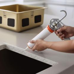 Acid-free silicone adhesive for undermount installation of stainless steel sinks